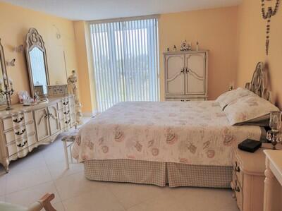 6699 Northwest 2nd Avenue, Unit PHI Boca Raton, FL 33487 - Photo 16 of 33 a bedroom with a bed dresser and a window