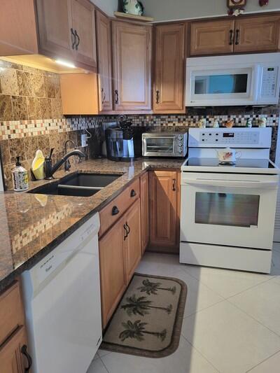 6699 Northwest 2nd Avenue, Unit PHI Boca Raton, FL 33487 - Photo 2 of 33 a kitchen with stainless steel appliances granite countertop a stove a sink and a microwave