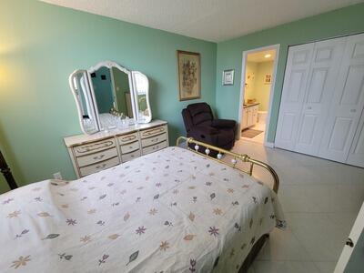 6699 Northwest 2nd Avenue, Unit PHI Boca Raton, FL 33487 - Photo 25 of 33 a bedroom with a bed a desk and chair