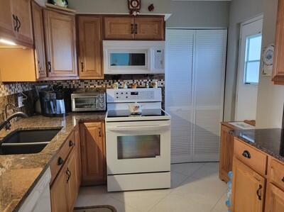 6699 Northwest 2nd Avenue, Unit PHI Boca Raton, FL 33487 - Photo 3 of 33 a kitchen with granite countertop a sink and a stove top oven
