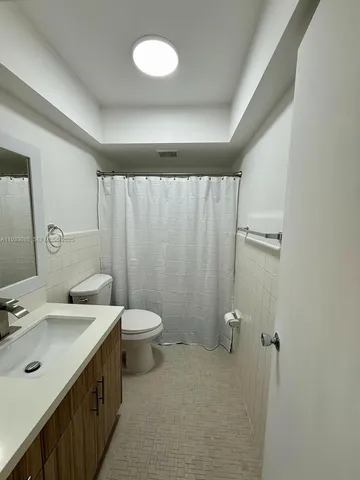 a bathroom with a double vanity sink toilet and a mirror