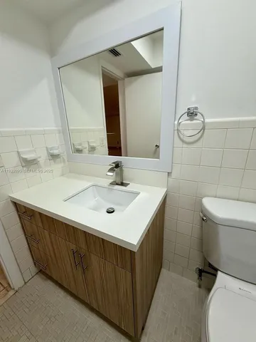 a bathroom with a sink toilet and mirror