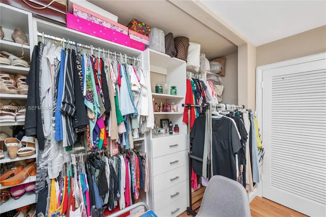 a view of walk in closet with clothes