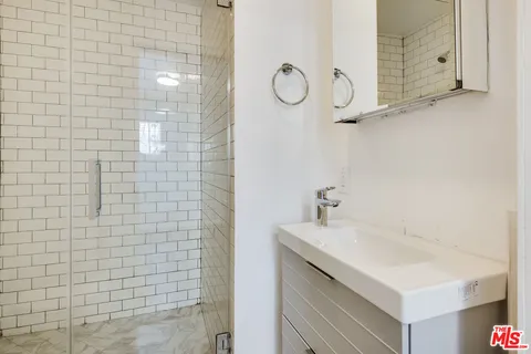 a bathroom with a sink a mirror and shower