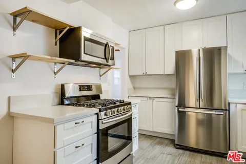 a kitchen with stainless steel appliances a refrigerator stove and microwave