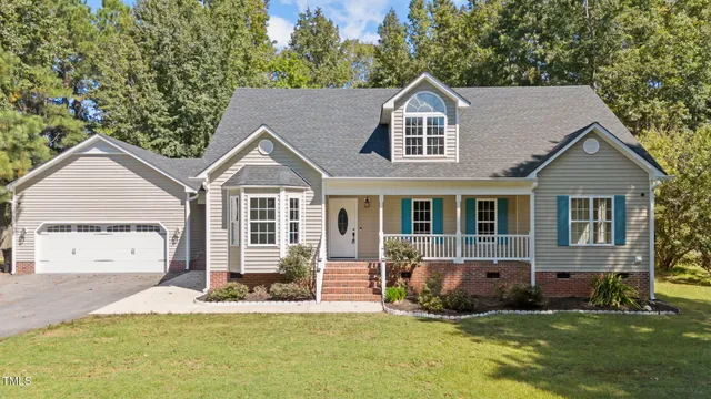 a view of a house with a yard and large tree
