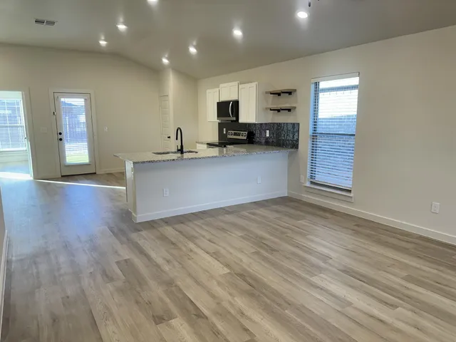 a view of kitchen with refrigerator microwave and stove