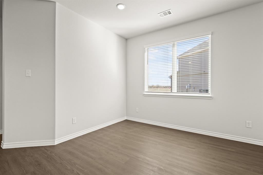 5025 Wellborn Road Crowley, TX 76036 - Photo 5 of 38 a view of an empty room with wooden floor and a window