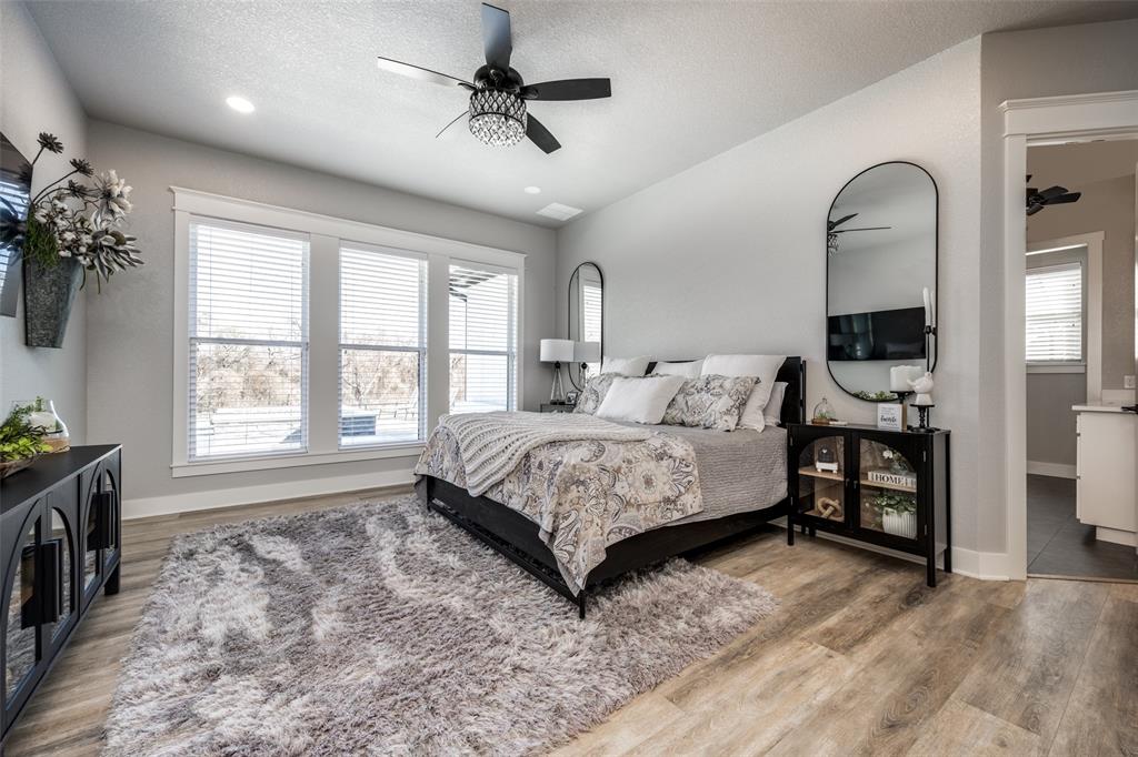 123 Proctor Lane Decatur, TX 76234 - Photo 18 of 25 a spacious bedroom with a bed a dresser and a large window