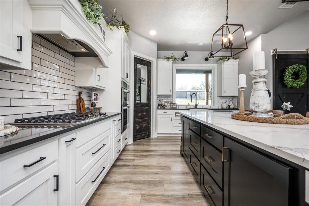 123 Proctor Lane Decatur, TX 76234 - Photo 6 of 25 a large kitchen with granite countertop a stove and a sink