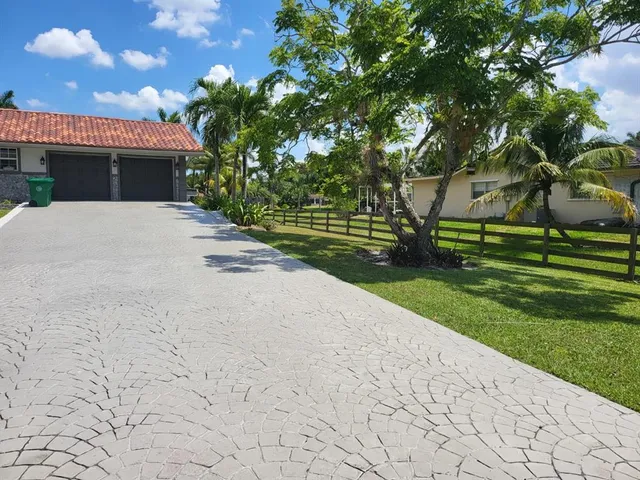 a front view of a house with a garden and yard