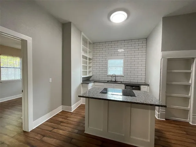 a kitchen with granite countertop a refrigerator and a sink