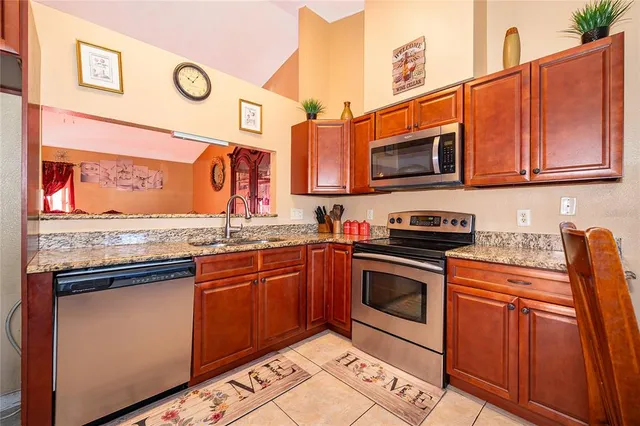 a kitchen with stainless steel appliances granite countertop a stove top oven a sink and dishwasher a oven with wooden floors