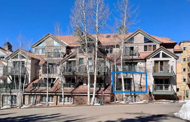 a front view of a residential apartment building with a small yard