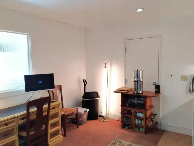 a view of a workspace with furniture and a lamp