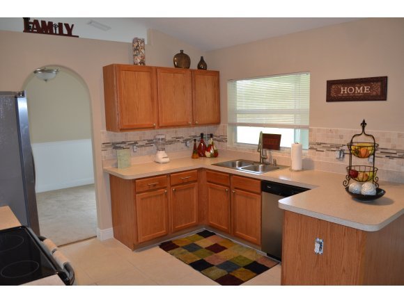 449 Southwest Scanlon Palm Bay, FL 32908 - Photo 4 of 12 a kitchen with stainless steel appliances kitchen island granite countertop a sink dishwasher stove and cabinets