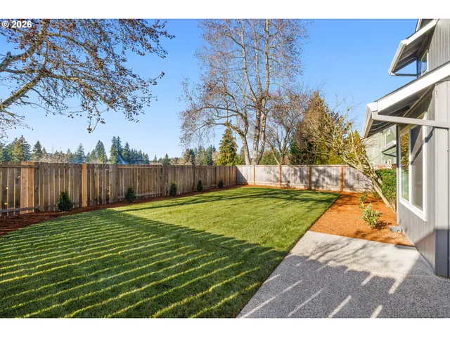 a view of a backyard with wooden fence