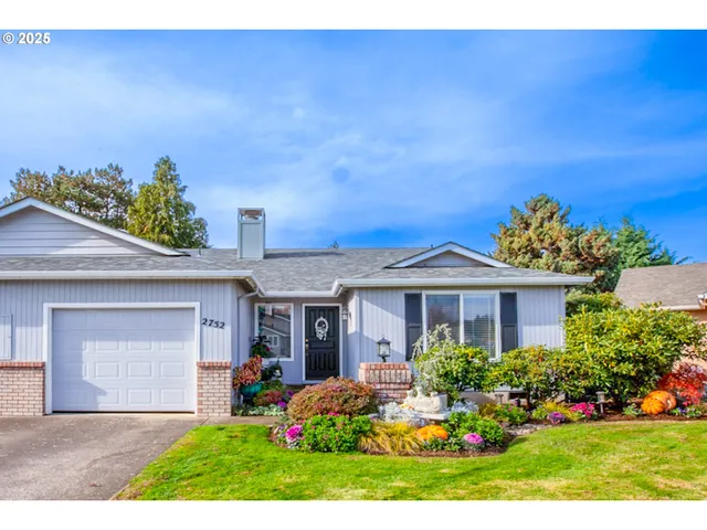a front view of a house with a yard and potted plants