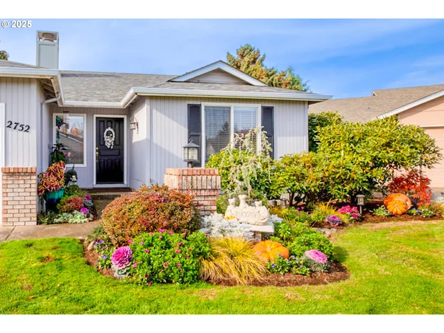a front view of a house with a big yard and potted plants