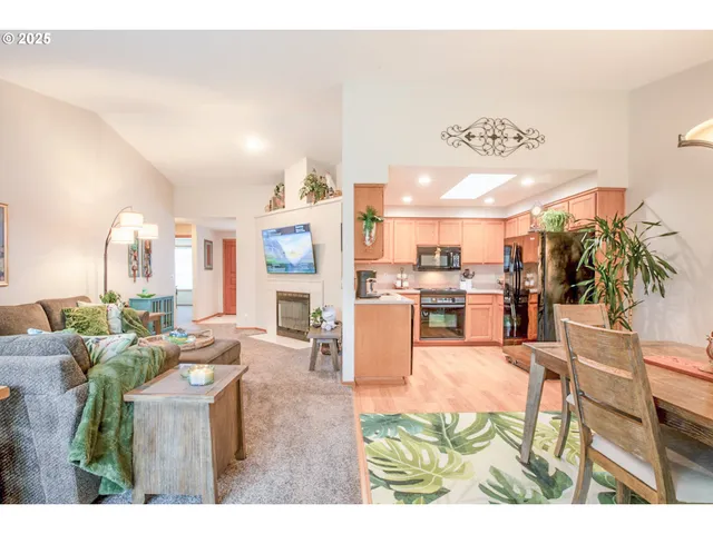 a living room with furniture a chandelier and kitchen view