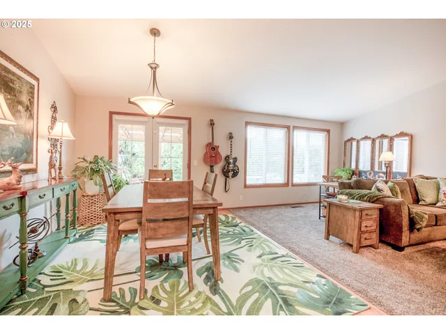 a living room with furniture two window and a dining table
