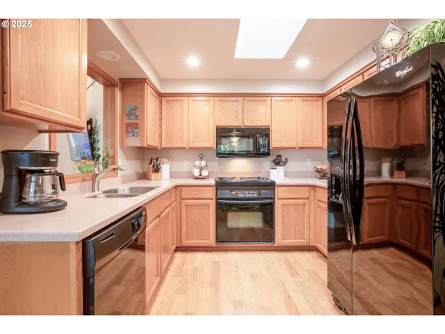 a kitchen with a sink a window stainless steel appliances and cabinets