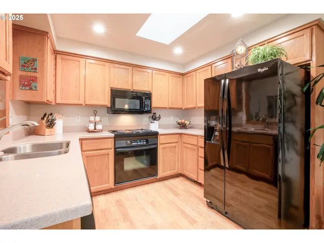 a kitchen with granite countertop a refrigerator stove and sink