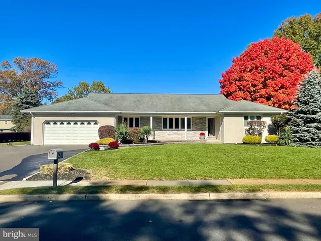a front view of a house with a garden and yard