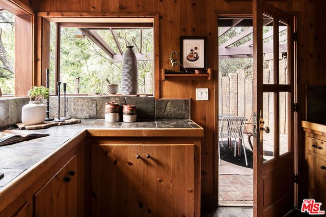 a kitchen with stainless steel appliances granite countertop a stove a sink and a granite counter tops with large windows