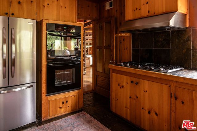 a kitchen with stainless steel appliances granite countertop a refrigerator and a stove