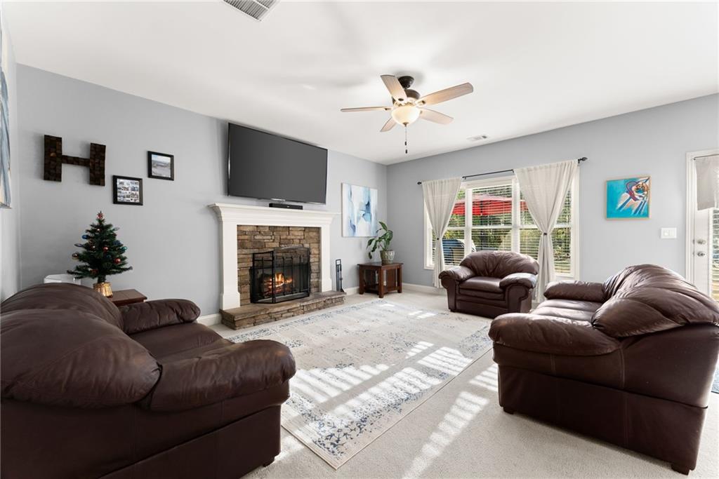 725 Larry Lane Winder, GA 30680 - Photo 13 of 62 a living room with furniture a flat screen tv and a fireplace