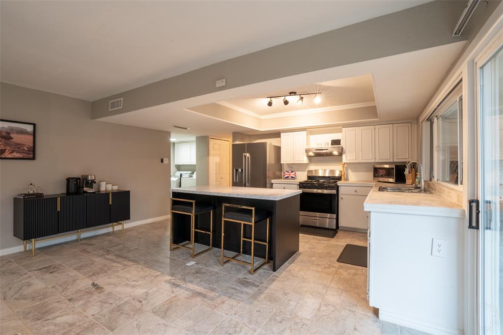 3124 Barton Road Carrollton, TX 75007 - Photo 18 of 36 a kitchen with kitchen island granite countertop a sink counter top space and appliances