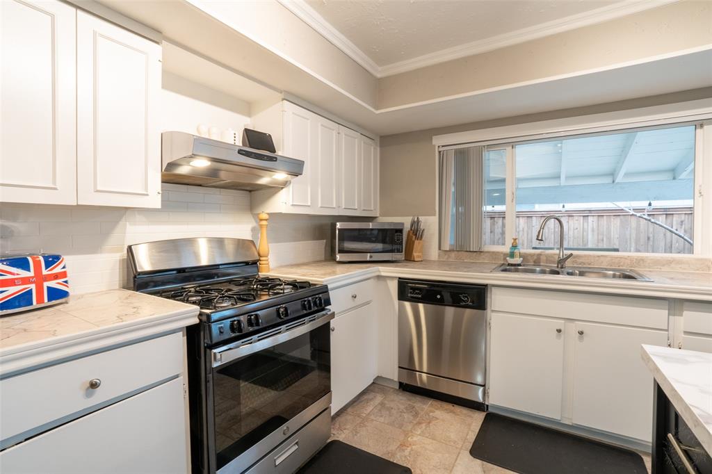 3124 Barton Road Carrollton, TX 75007 - Photo 22 of 36 a kitchen with stainless steel appliances a stove and cabinets