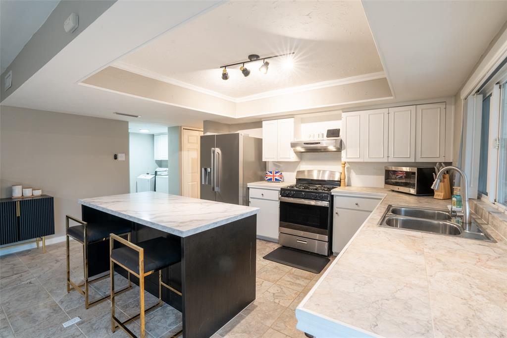 3124 Barton Road Carrollton, TX 75007 - Photo 25 of 36 a kitchen with a stove a refrigerator and a sink
