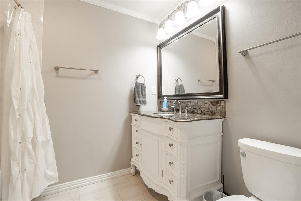 3124 Barton Road Carrollton, TX 75007 - Photo 33 of 36 a bathroom with a sink a toilet and a mirror