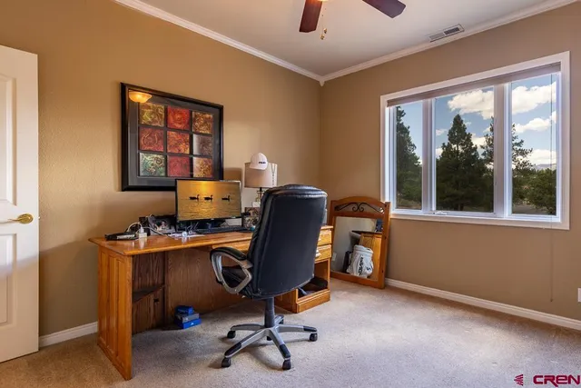 a view of a workspace with furniture and a window