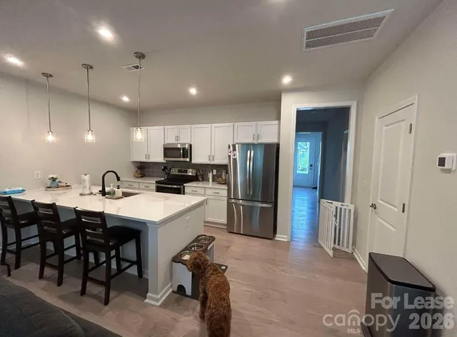 a kitchen with refrigerator and chairs