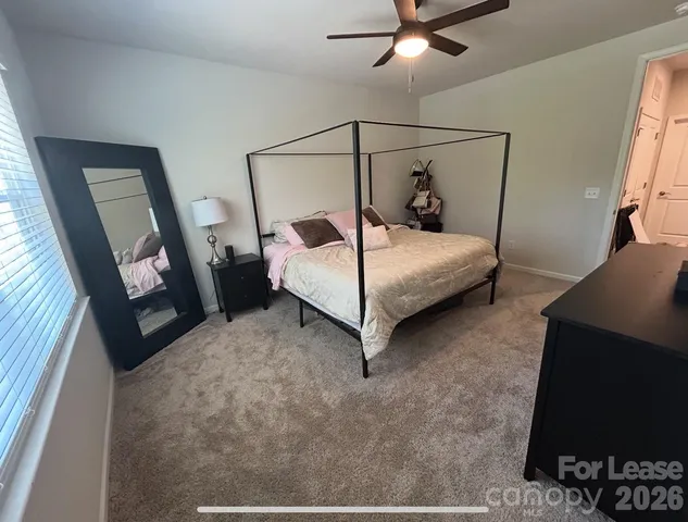 a bedroom with a bed and a flat tv screen on the dresser