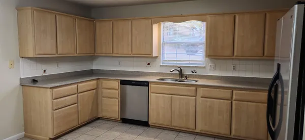 a kitchen with cabinets appliances a sink and a window