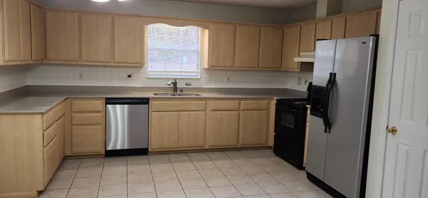 a kitchen with a sink a refrigerator and cabinets