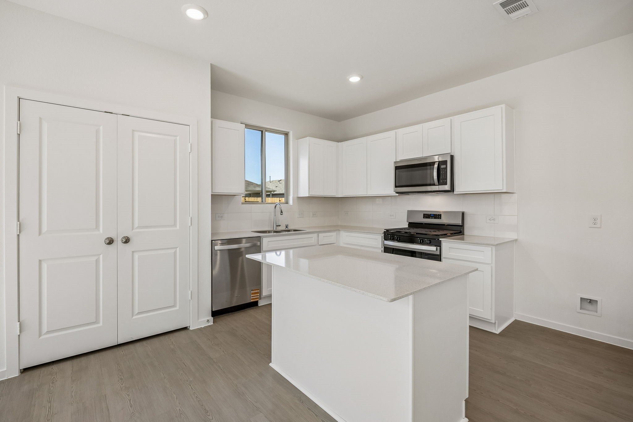 15015 Rustic Moon Road Conroe, TX 77302 - Photo 7 of 34 a kitchen with cabinets stainless steel appliances and a window