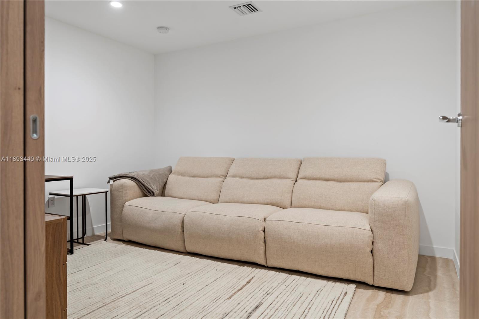 1135 103rd Street, Unit PH2 Bay Harbor Islands, FL 33154 - Photo 14 of 20 a living room with a couch and a wooden floor