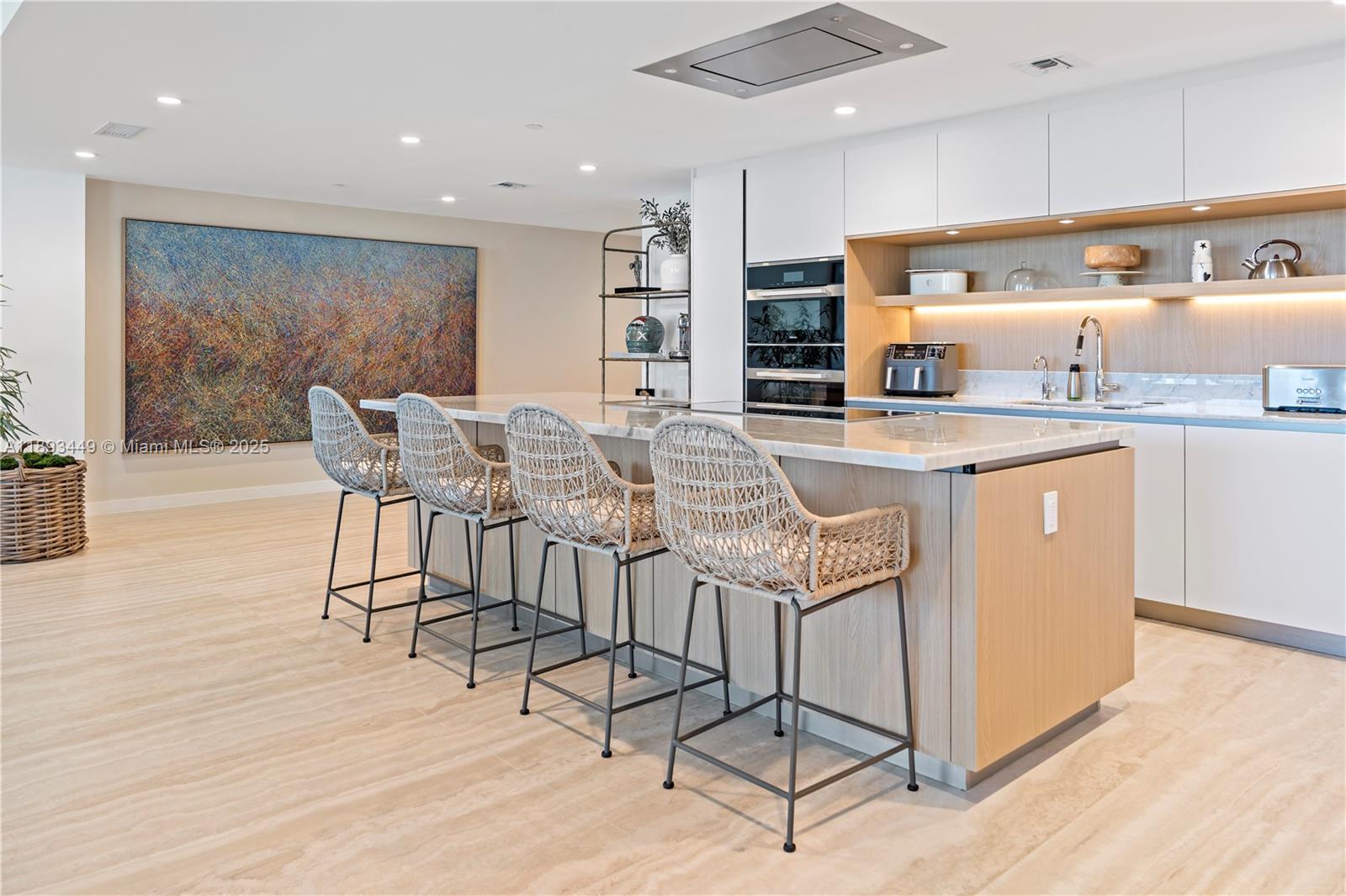 1135 103rd Street, Unit PH2 Bay Harbor Islands, FL 33154 - Photo 7 of 20 a kitchen with stainless steel appliances granite countertop a stove a sink a refrigerator and white cabinets with wooden floor