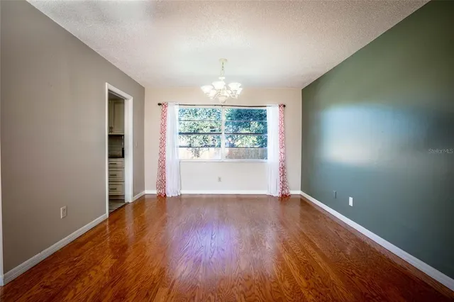 a view of a dining room with furniture a chandelier and wooden floor