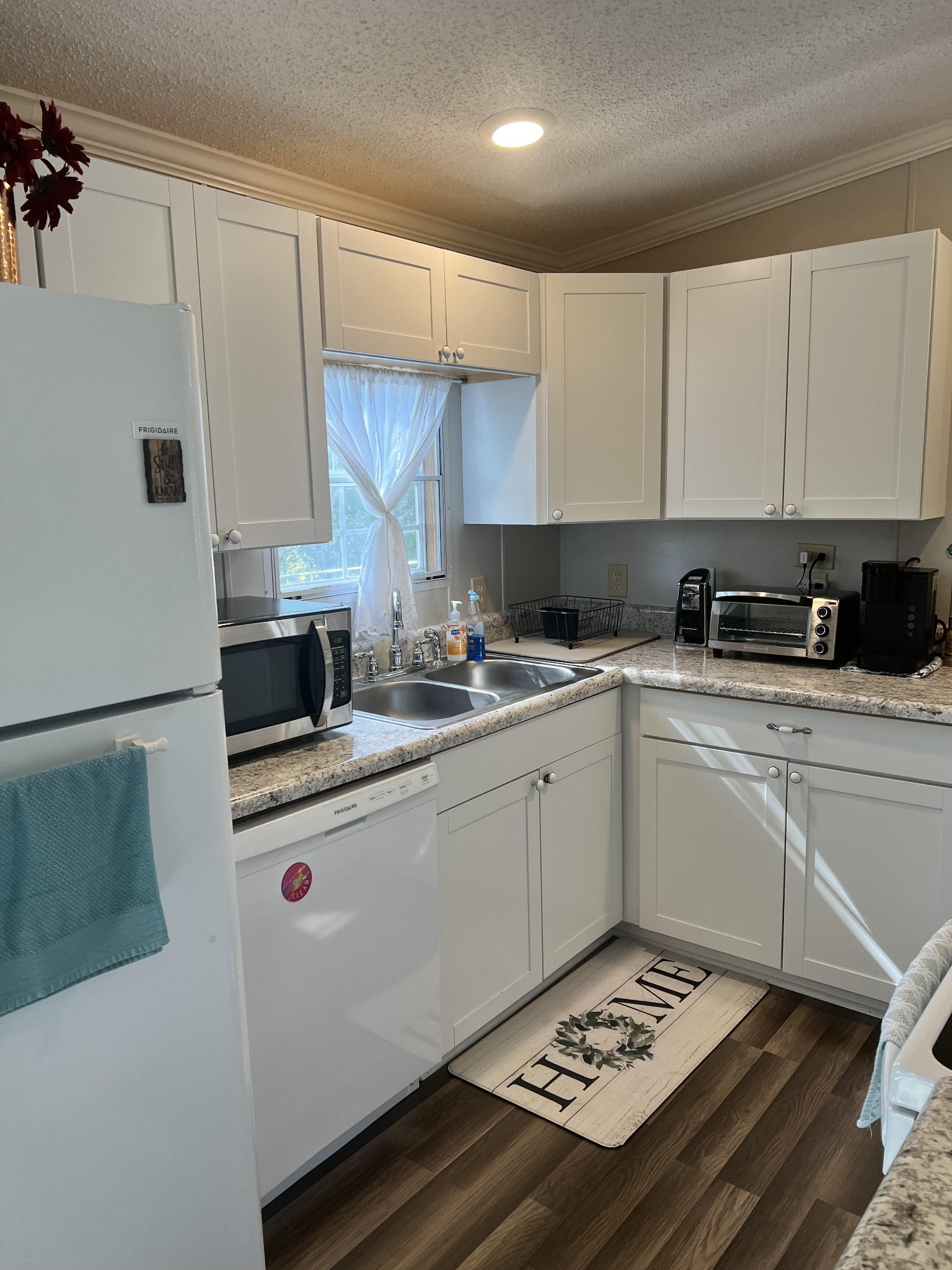 20002 Cessna Road Bon Aqua, TN 37025 - Photo 13 of 28 a kitchen with a sink stove and white cabinets
