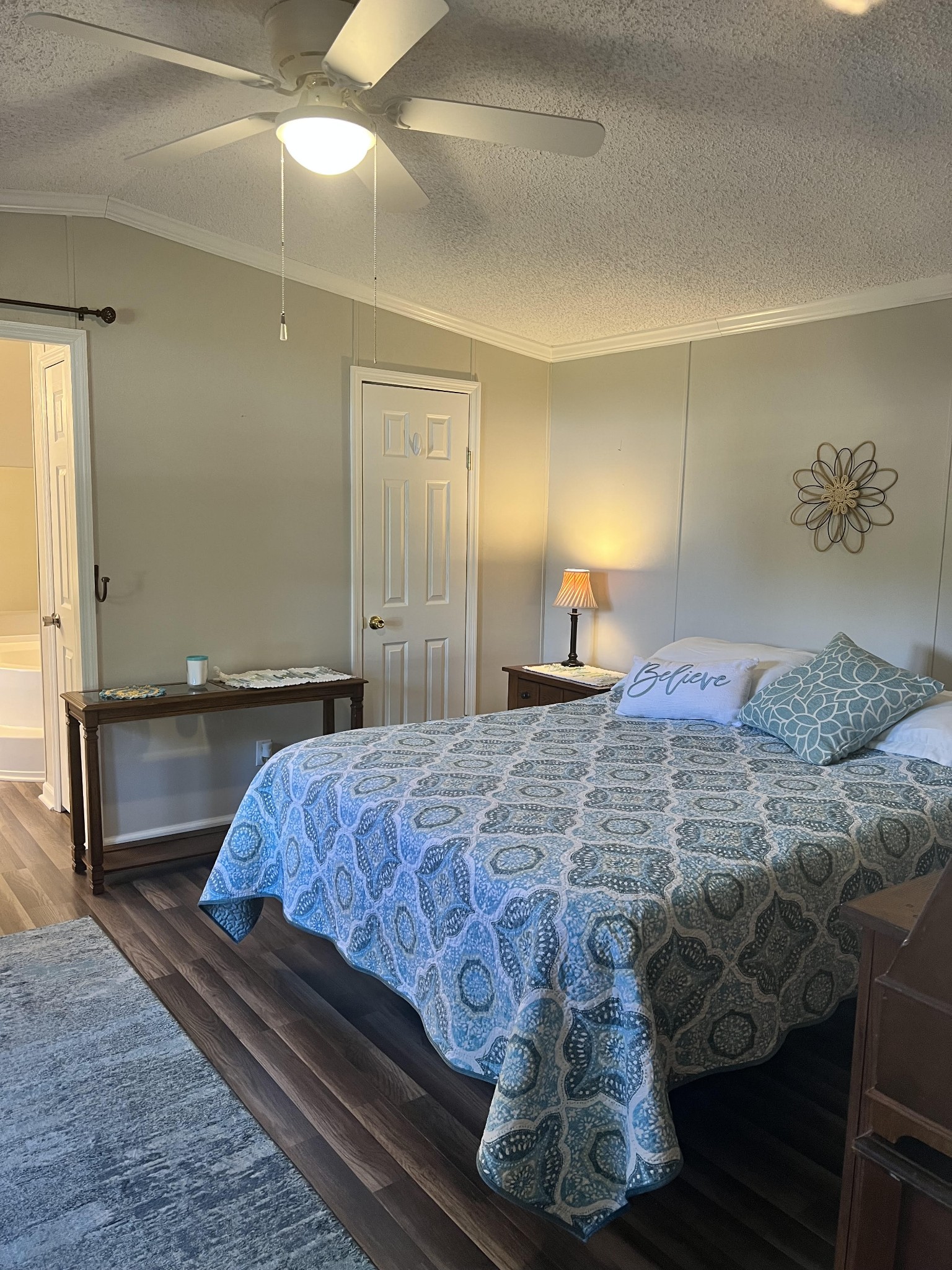 20002 Cessna Road Bon Aqua, TN 37025 - Photo 17 of 28 a bedroom with a large bed and a chandelier