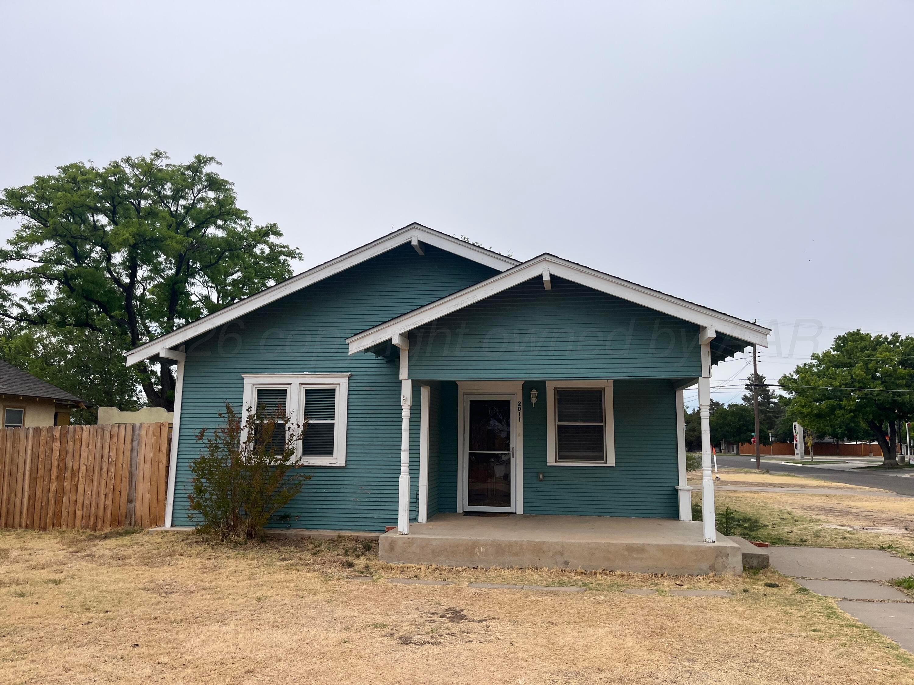 a front view of a house with a garden and yard