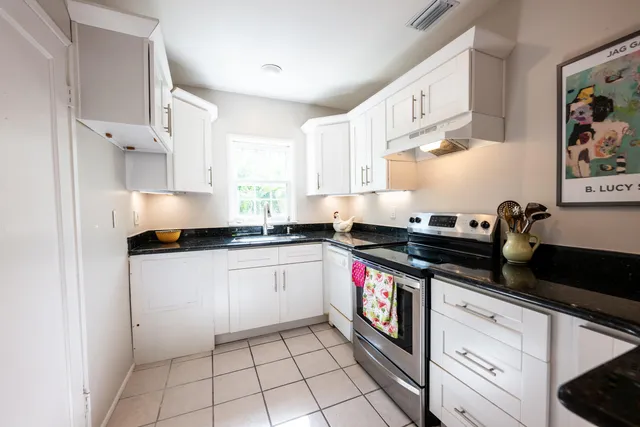 a kitchen with stainless steel appliances granite countertop a stove a sink and a refrigerator
