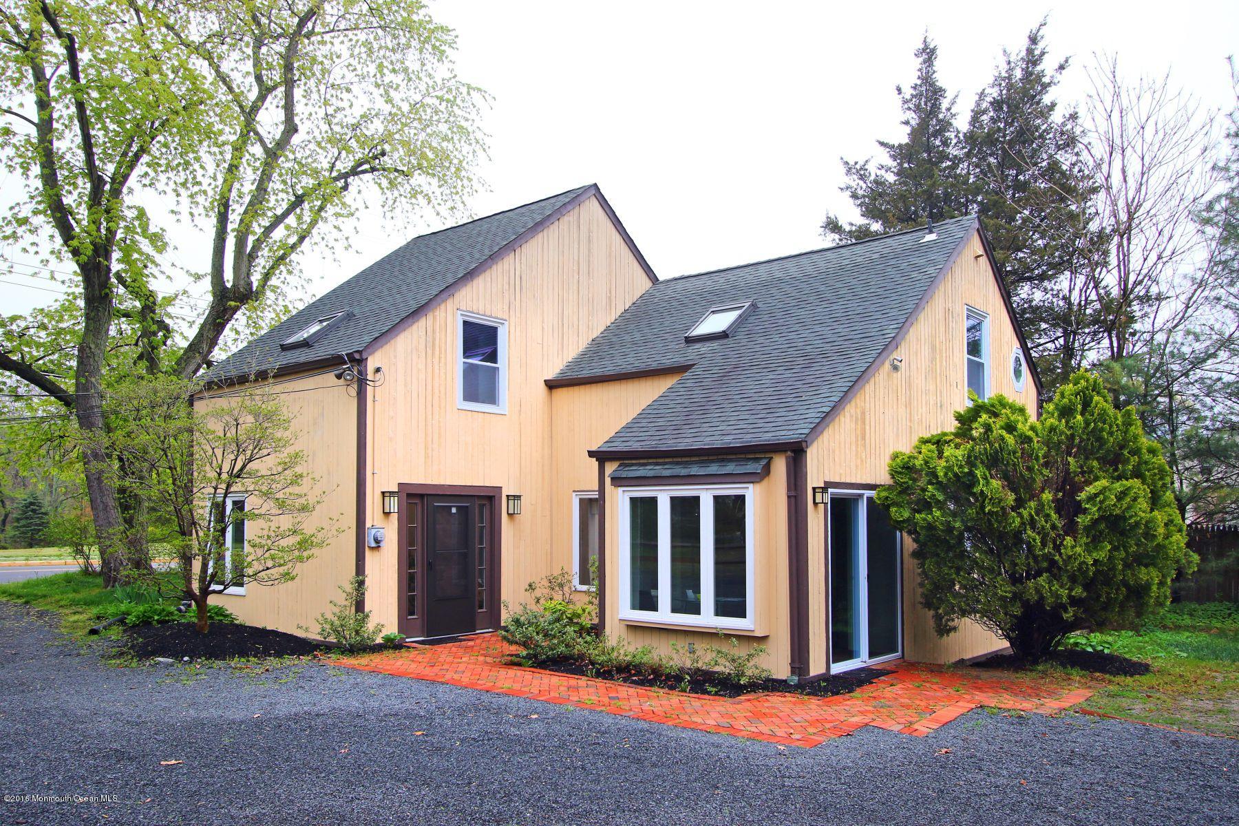 186 Pinebrook Road Tinton Falls, NJ 07724 - Photo 11 of 41 a view of a brick house next to a yard with large trees