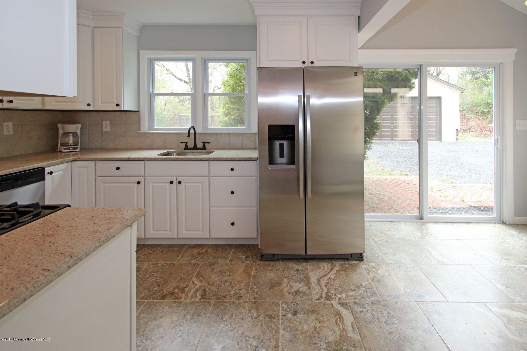 186 Pinebrook Road Tinton Falls, NJ 07724 - Photo 18 of 41 a kitchen with granite countertop a refrigerator a sink a stove and cabinets